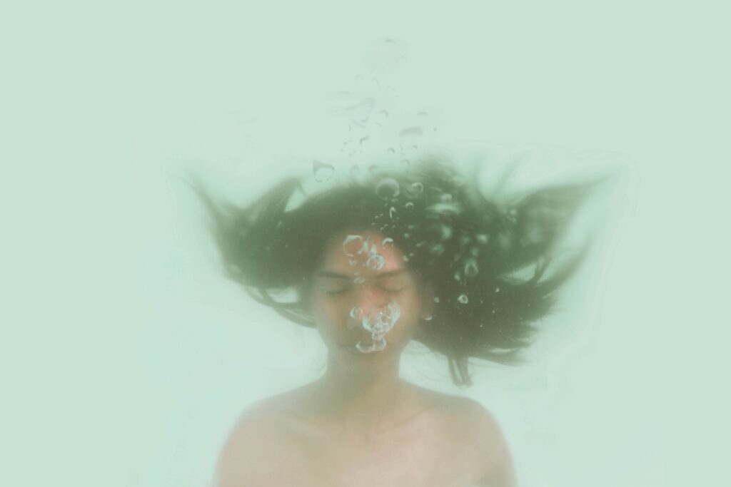 Mujer bajo el agua, en apnea para mantenerse.